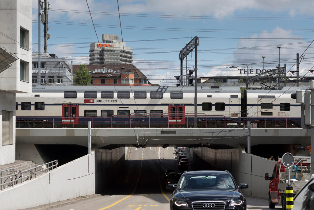 A passenger train passing over an underpass in Zurich