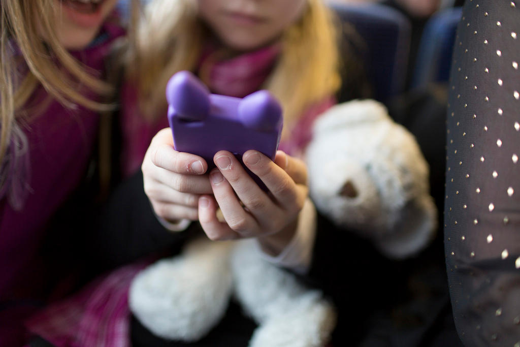 child with smartphone and teddy bear