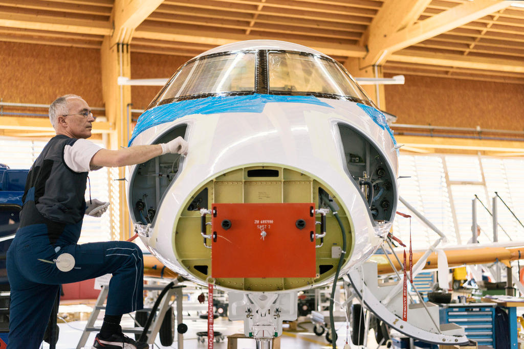 Ein Mitarbeiter arbeitet an der Nase eines Flugzeugs