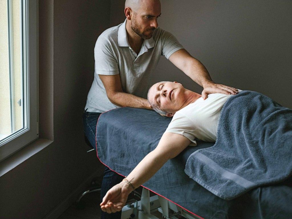 un uomo massaggia una donna distesa su un lettino