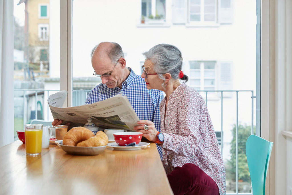 older couple at breakfast with newspaper