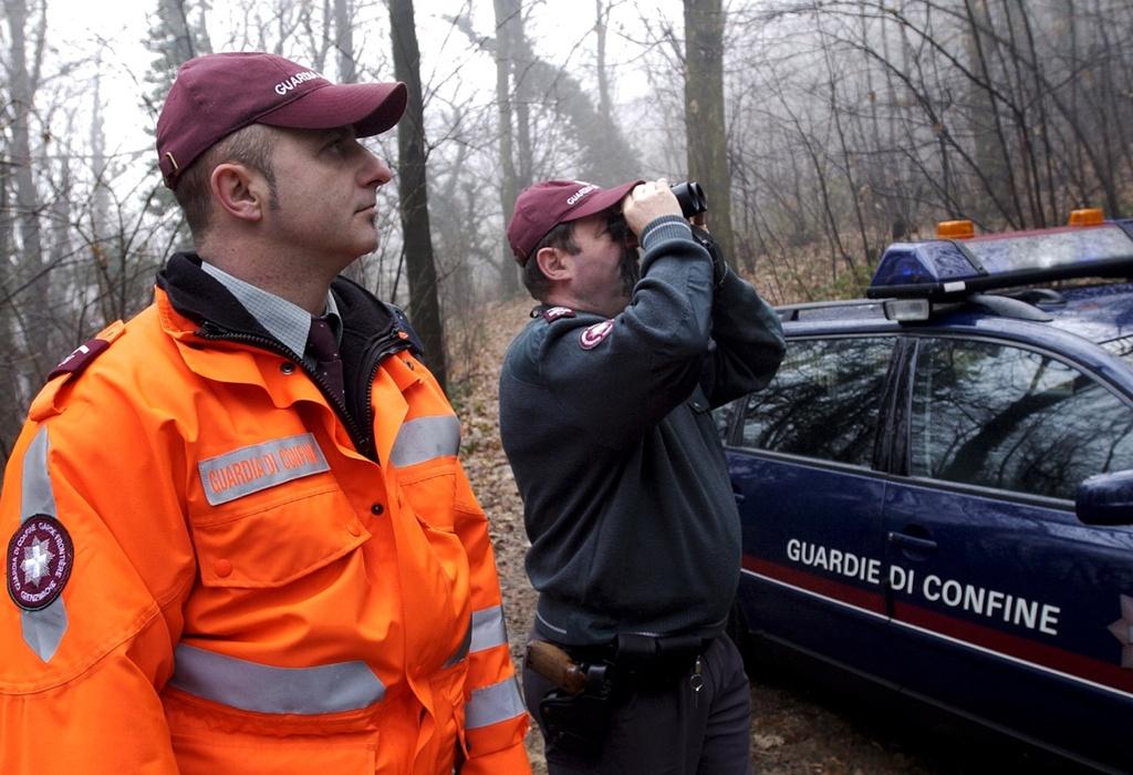 Guardie di confine che sorvegliano un passaggio nei boschi tra Italia e Svizzera