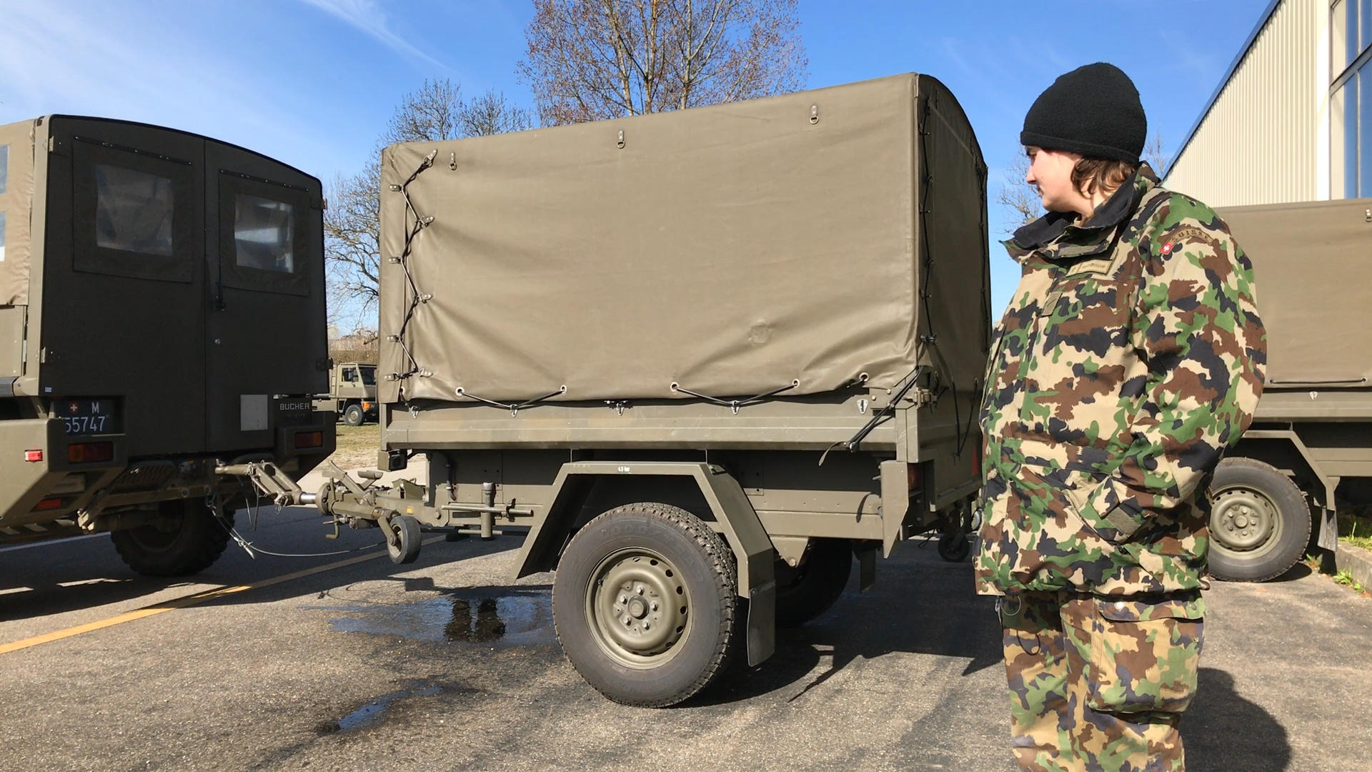 Soldatin steht vor einem militärischen Anhänger