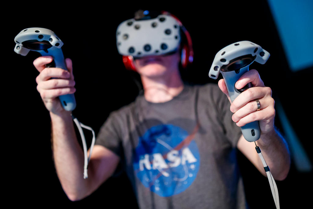 A man demonstrates virtual reality (VR) goggles and controllers before the Design Night in Neuchatel in October 2017