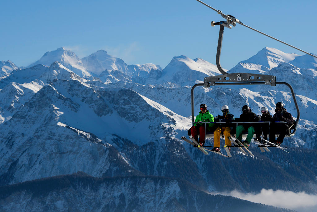 skiers ride a ski lift in Crans Montana