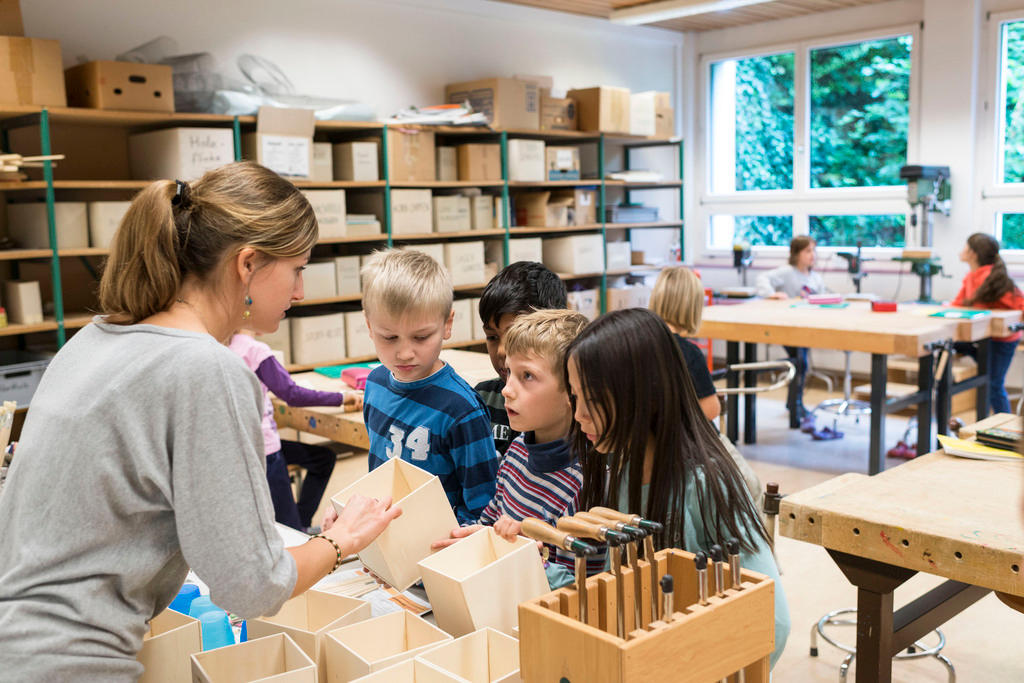 Maestra con tres alumnos de primaria