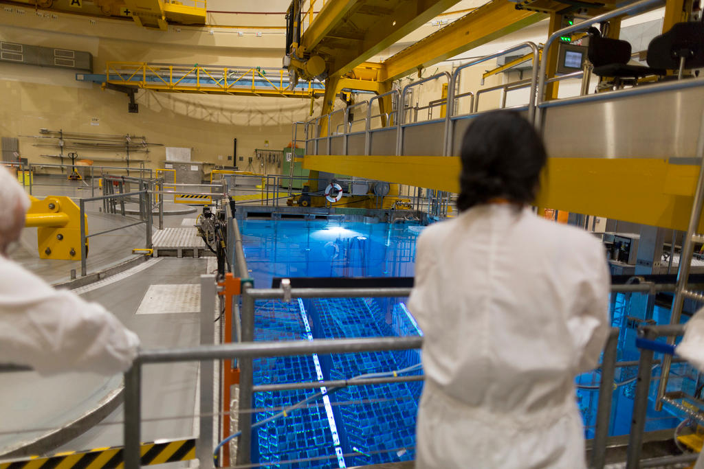 A worker observes a cooling unit inside a power plant