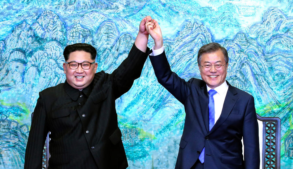North Korean leader Kim Jong Un, left, and South Korean President Moon Jae-in raise their hands after signing a joint statement
