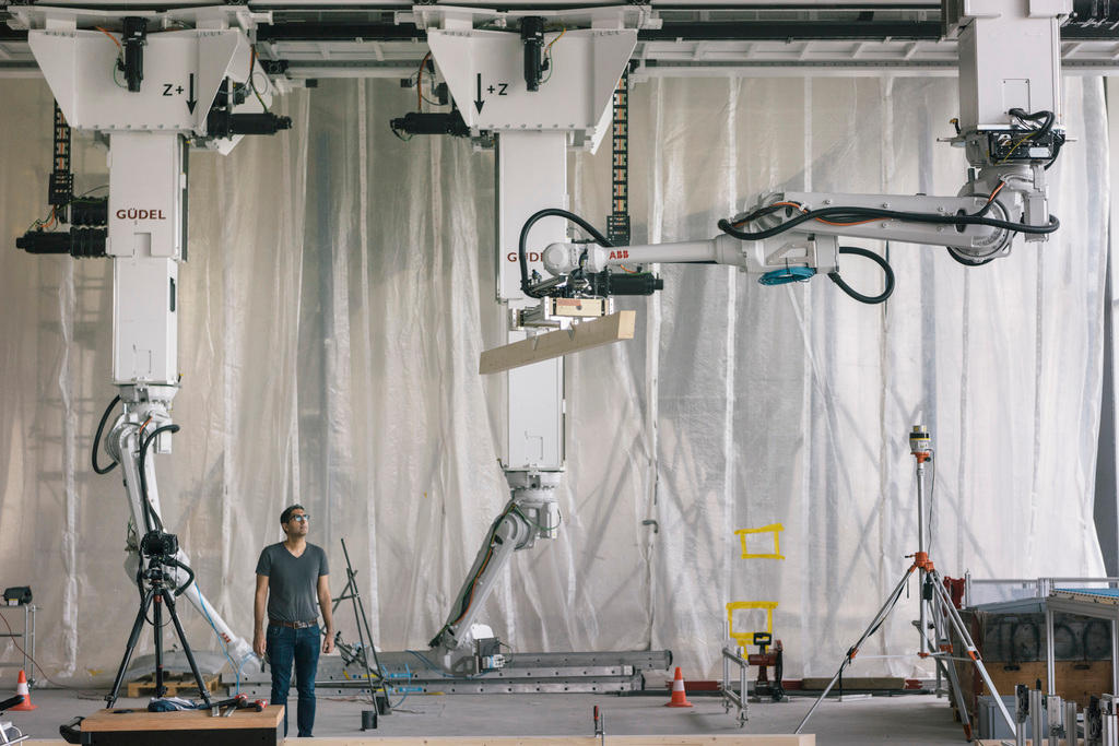 A robot arm moves a wooden beam in a research centre