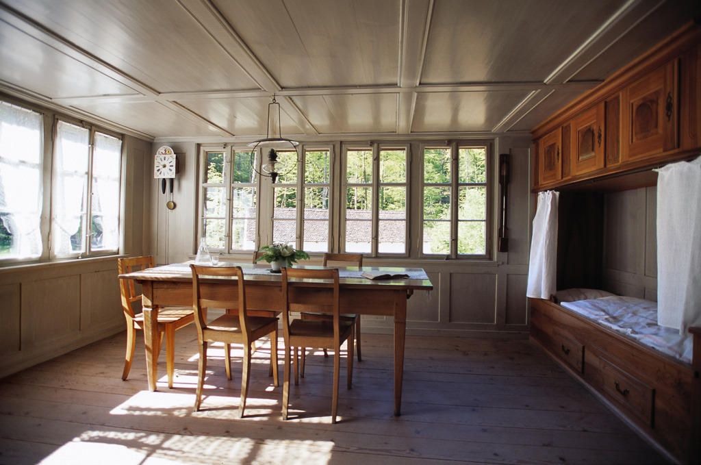 Un antica e spaziosa sala da pranzo, con mobilio di legno.