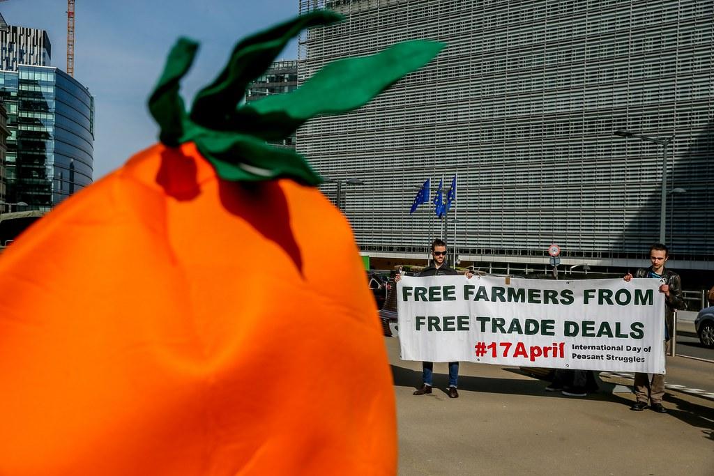Protestors hold up a banner against free trade deals