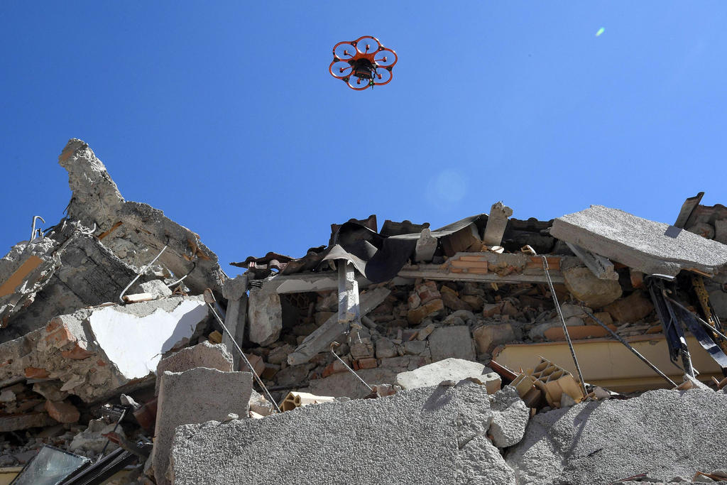 A drone flies over the debris of Amatrice school, central Italy, Friday, Sept. 2, 2016 following an earthquake