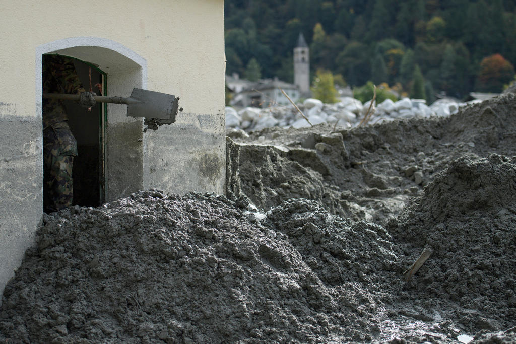 The army clears houses affected by the debris flow from the Bondo landslide in August 2017 