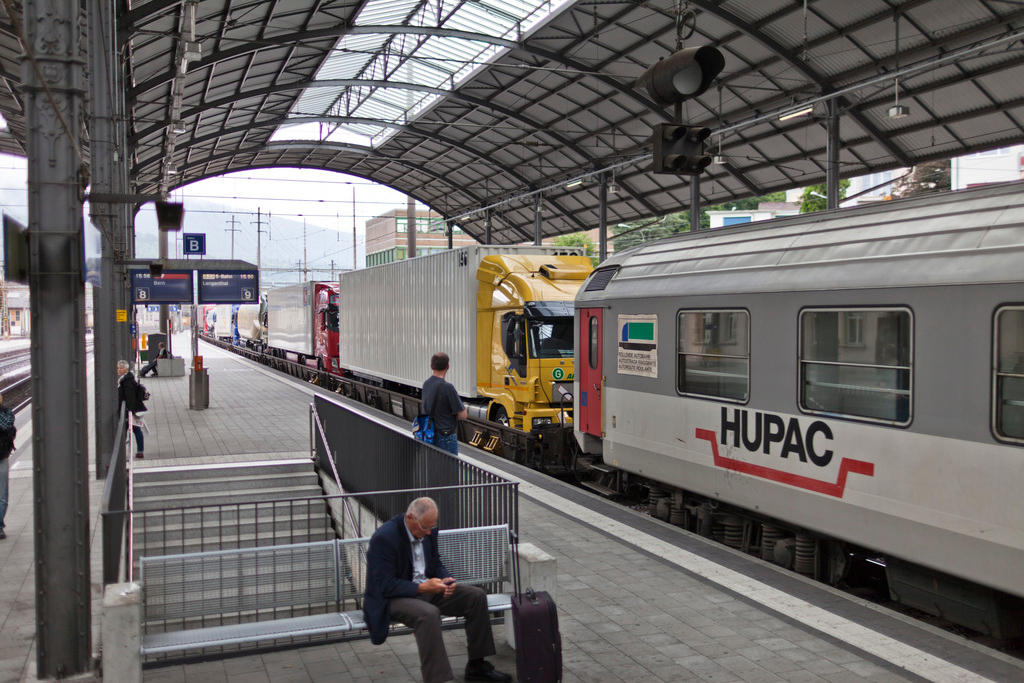 Camion su treno attraversano una stazione