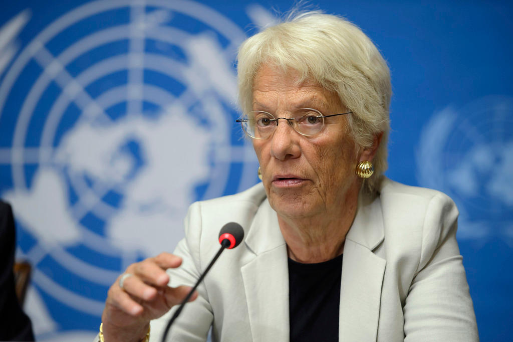 Eine Frau mit Brille spricht vor dem Logo der UNO in ein Mikrofon.