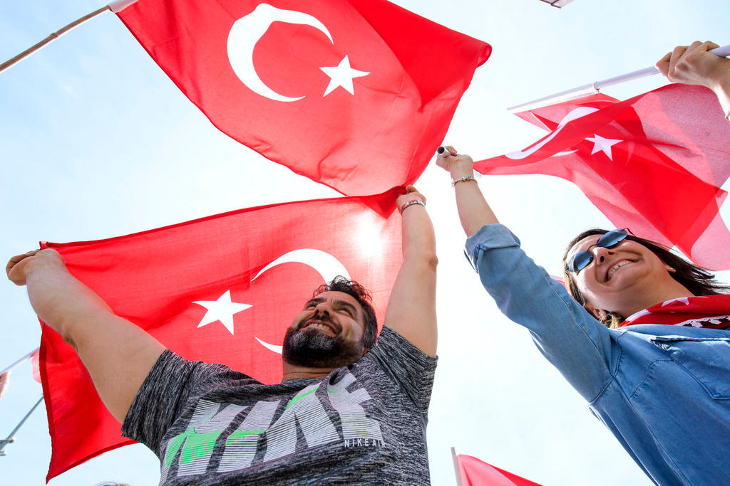 مؤيدون أتراك للرئيس أردوغان يُلوحون بأعلام بلادهم الحمراء والبيضاء
