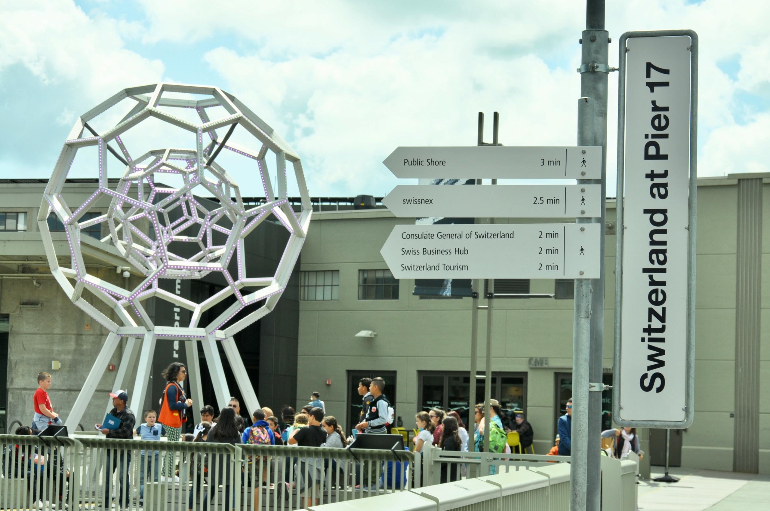 Signalschild Switzerland at Pier 17 und verschiedene Wegweiser