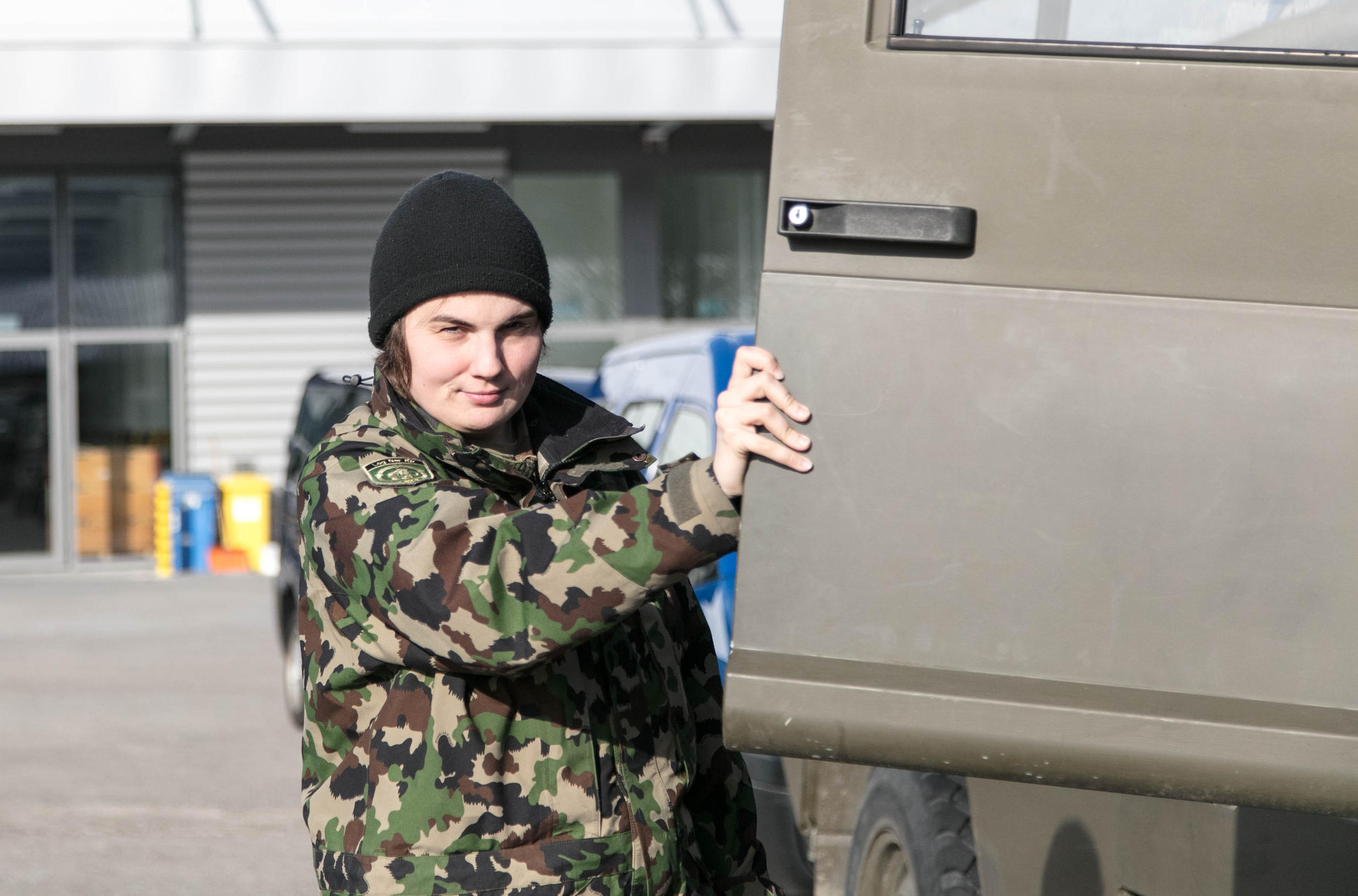 Zoé opens the door of her army truck