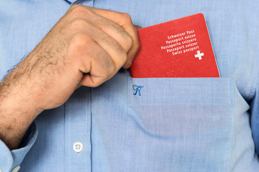 Schweizer Pass in der Brusttasche eines hellblauen Männerhemds