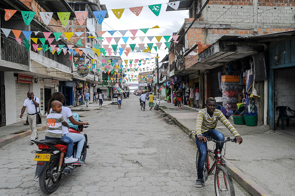 street with pedestrians and cyclists, with bunting hanging