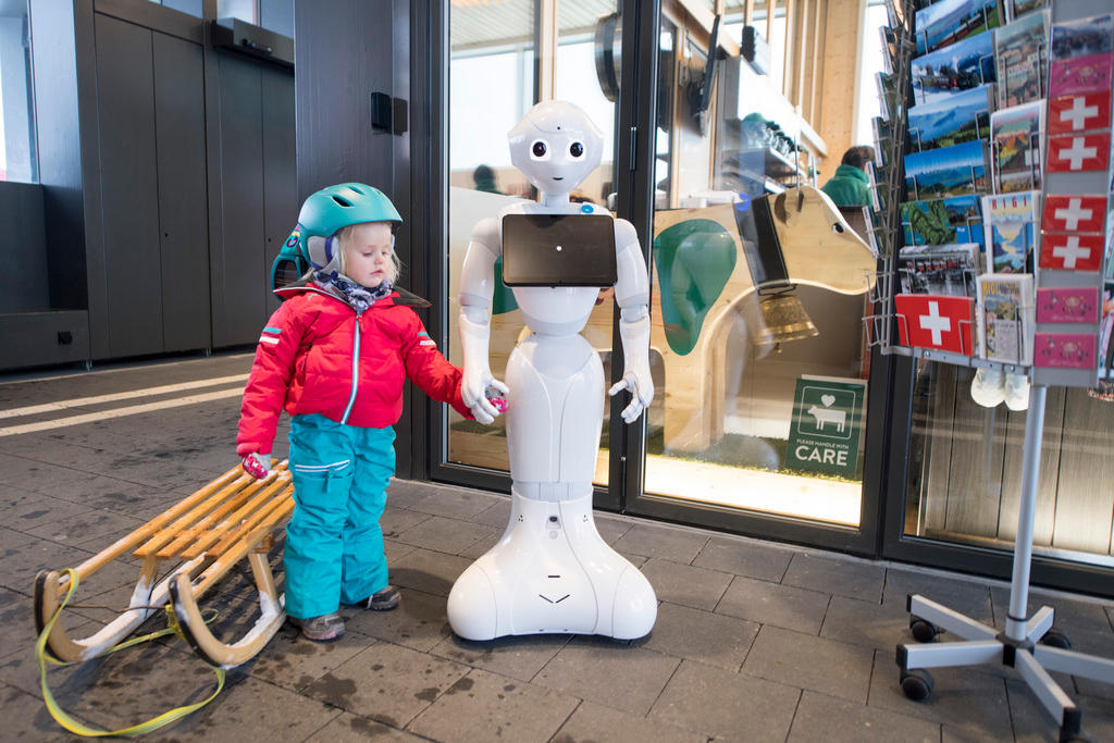 Young girl holds a robot s hand