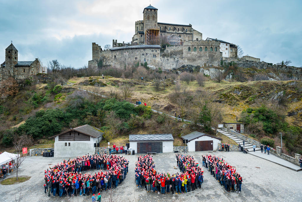 Sion 2026: pessoas reunidas em forma de oui