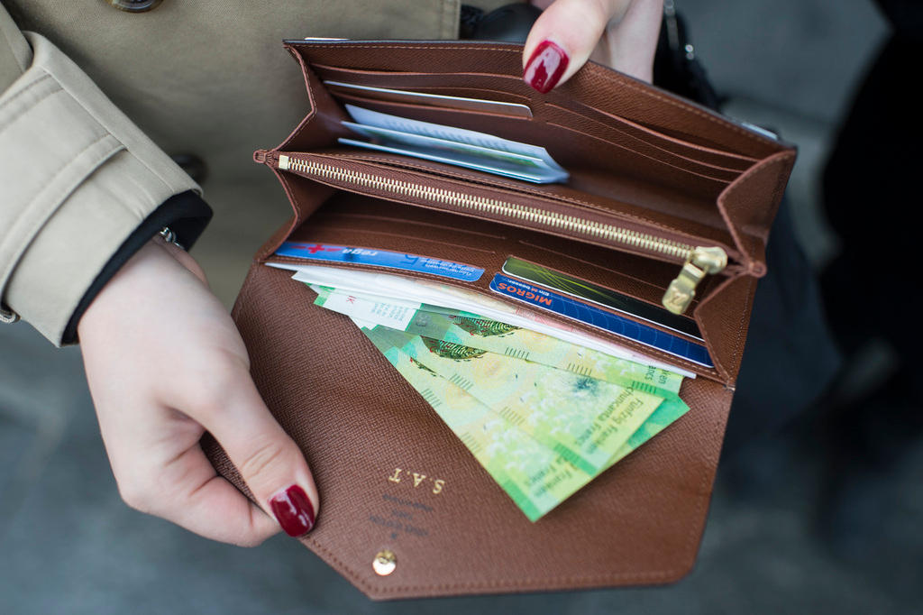 A picture of a woman holding open her purse.