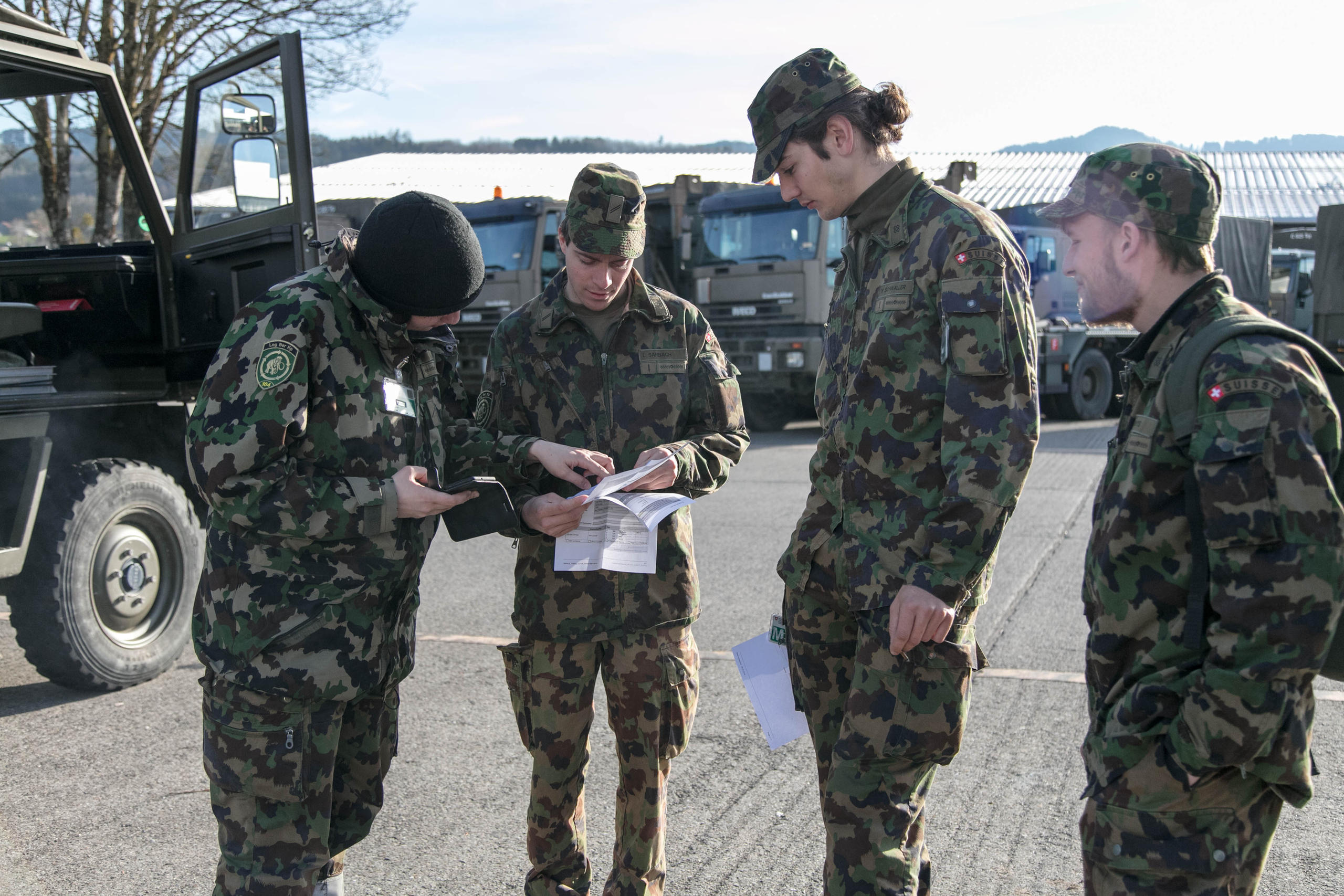 Vier Soldaten stehen im Kreis und schauen auf ihre Unterlagen
