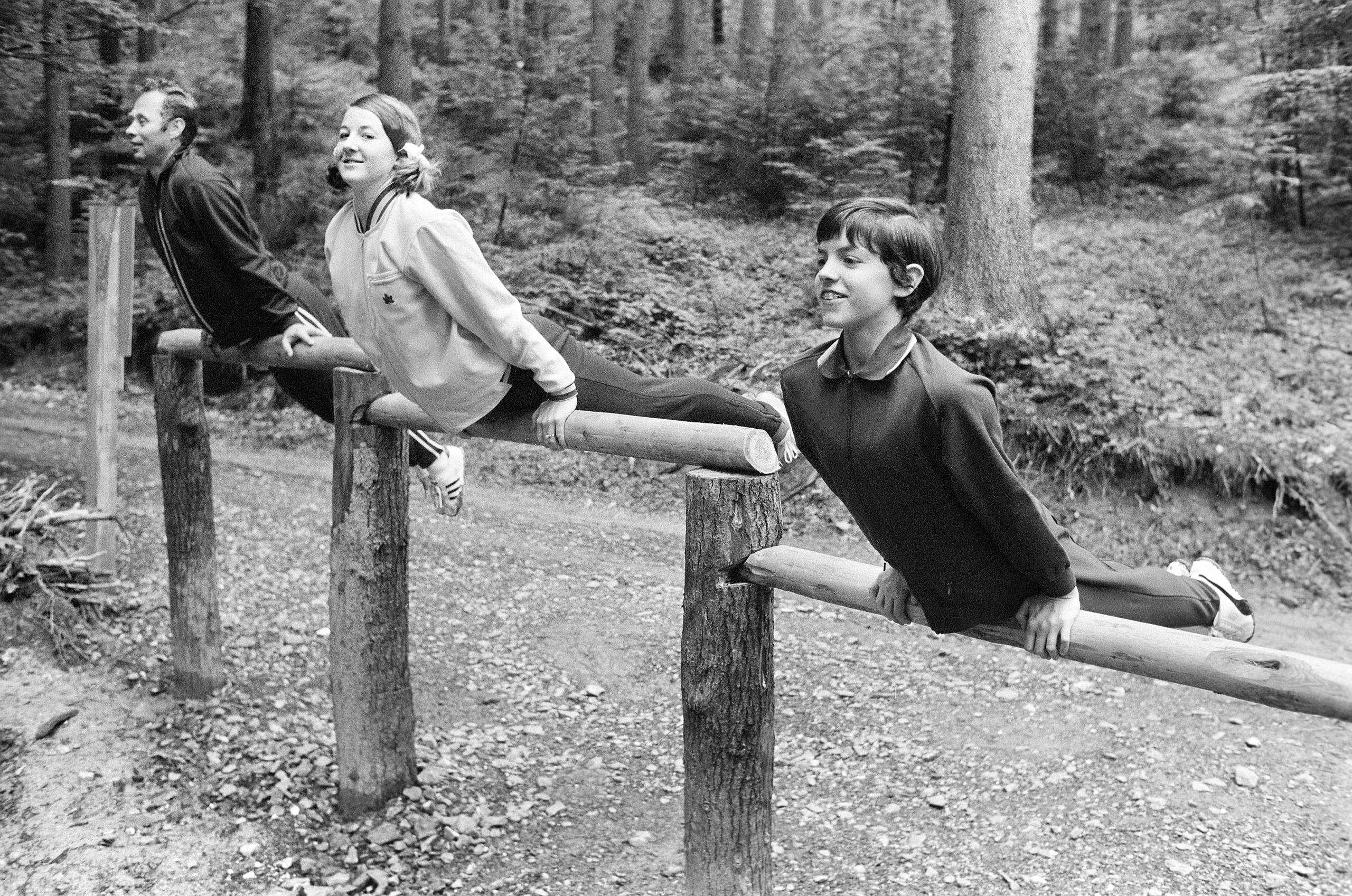 Tres gimnastas muestran sus habilidades durante la inaguración de un sendero deportivo en Lucerna el 17 de junio de 1971.