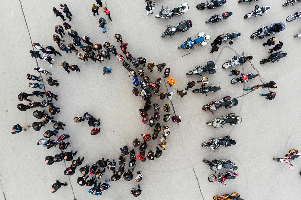 Imagem aérea de motoqueiros em círculo