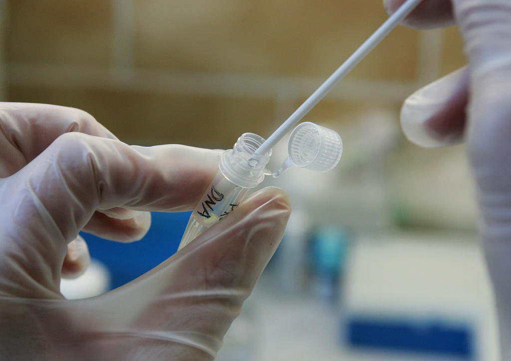 Hand of a chemist showing the procedure for a DNA analysis