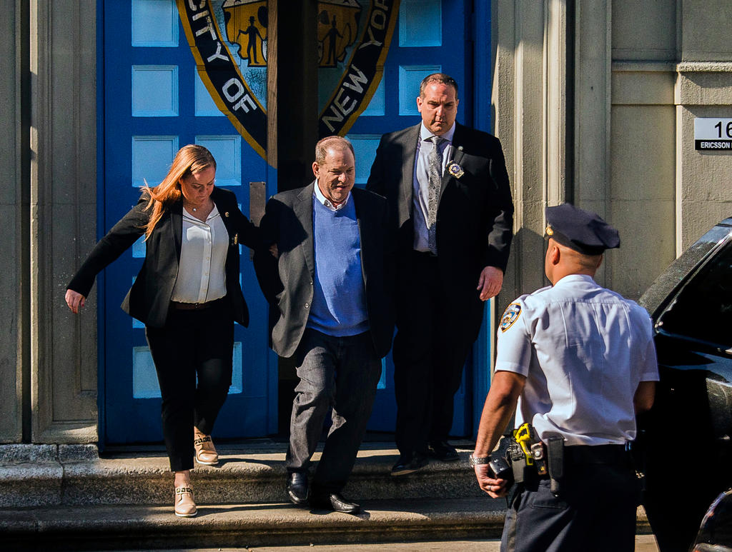 Harvey Weinstein is loaded into an unmarked vehicle