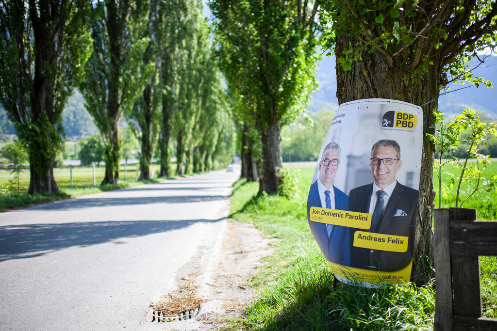 Election poster for the Graubünden elections in an alley of trees