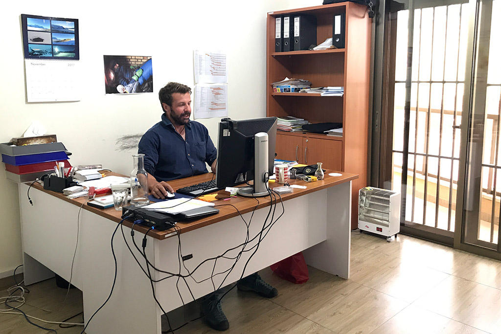 Um homem sentado à mesa na frente do computador