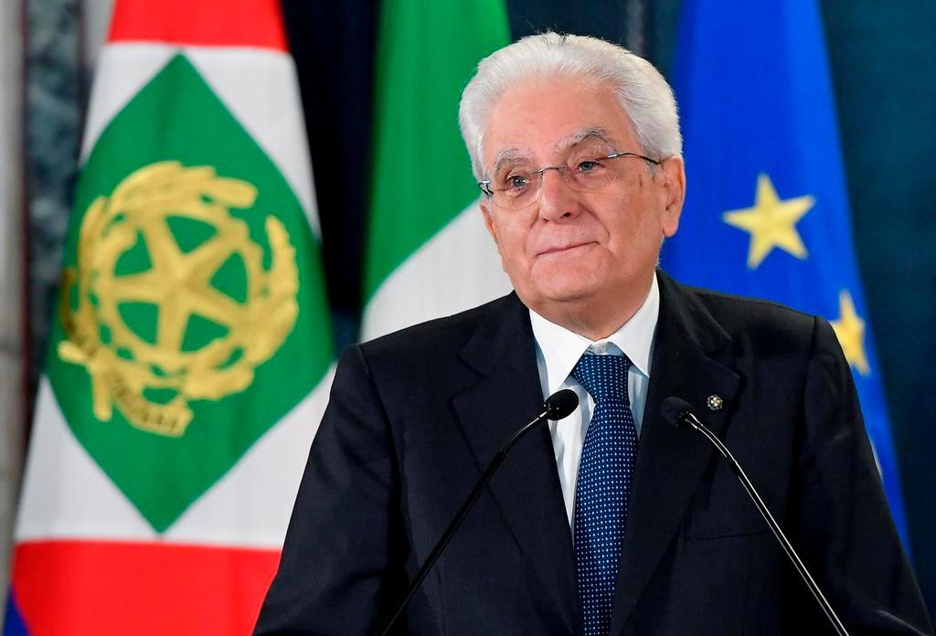 Sergio Mattarella fotografato con dietro le bandiere dell italia e dell Union europea