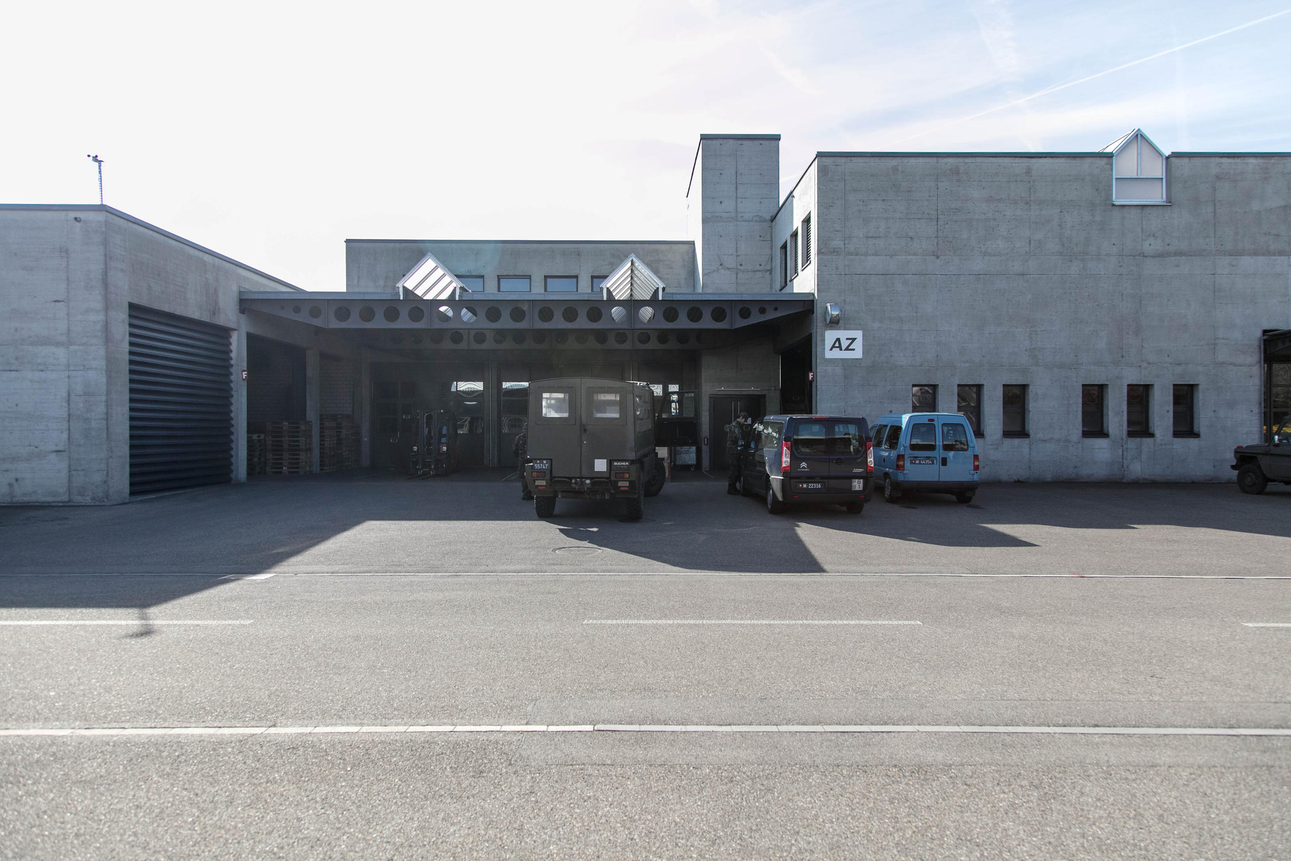 Un cuartel militar casi vacío, hay solo dos automóviles.