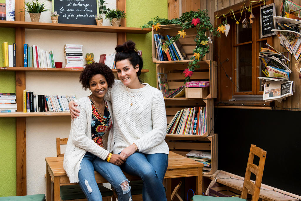 young woman migrant and host with books