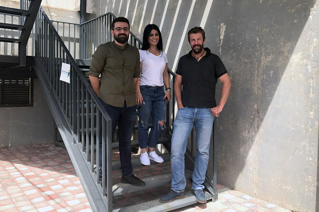 Dois homens e uma mulher posando para a câmera