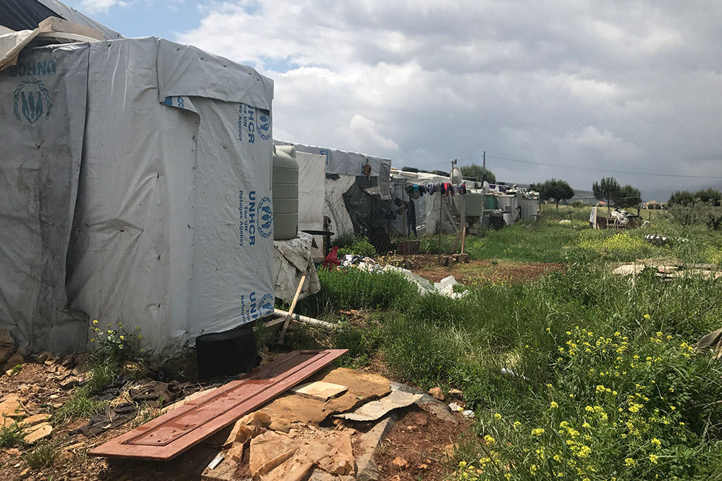 Water tanks behind a row of tents in a Syrian refugee camp in Lebanon.