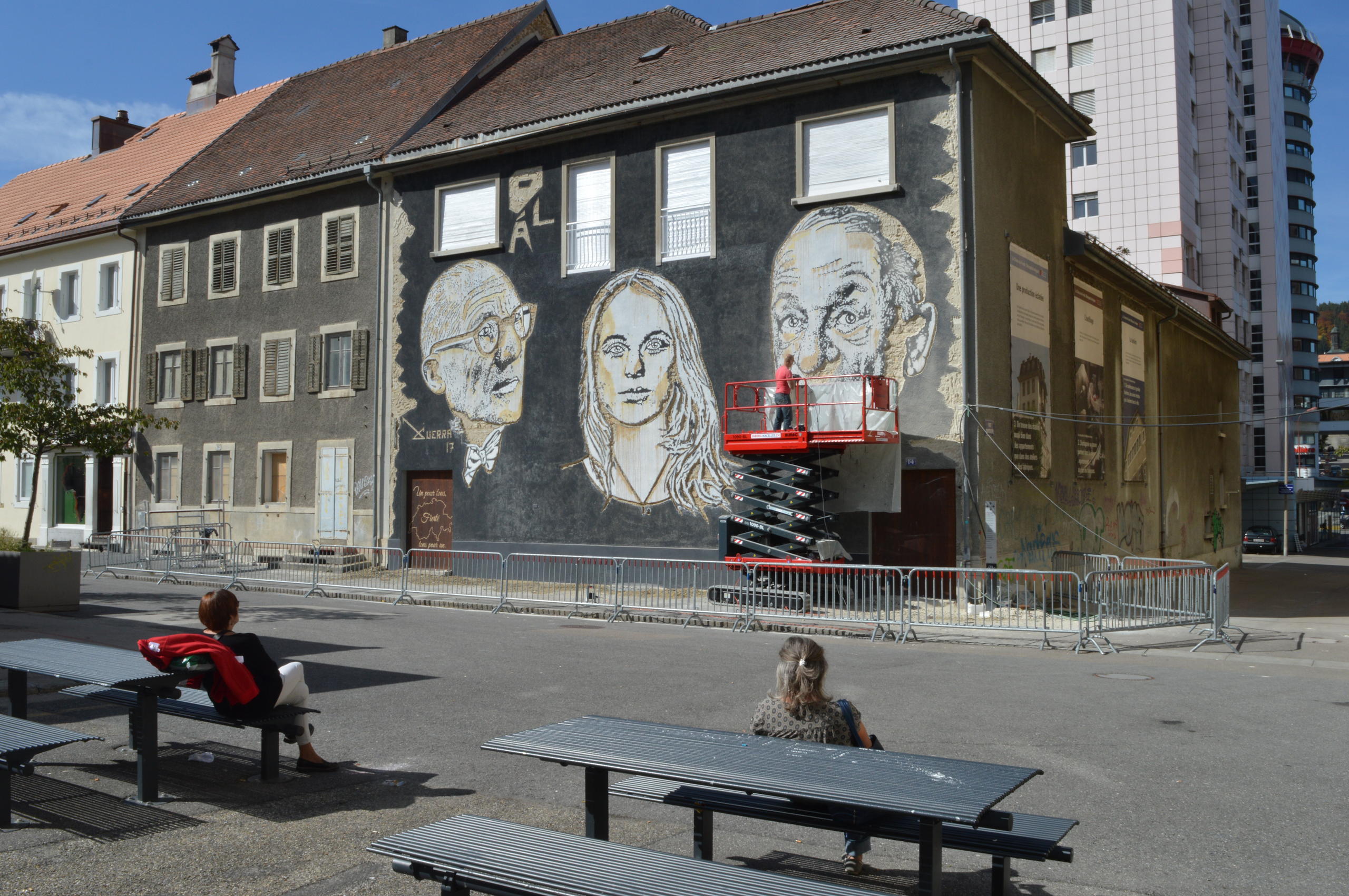 Mural de prédio pintado frente a uma praça