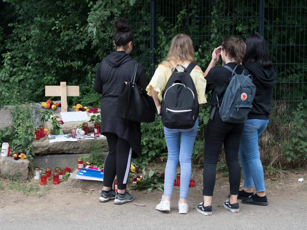 Jugendliche auf dem Friedhof an einem Grab