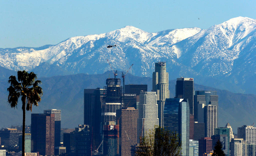 Snow-capped San Gabriel Mountains against a backdrop to Los Angeles skyline