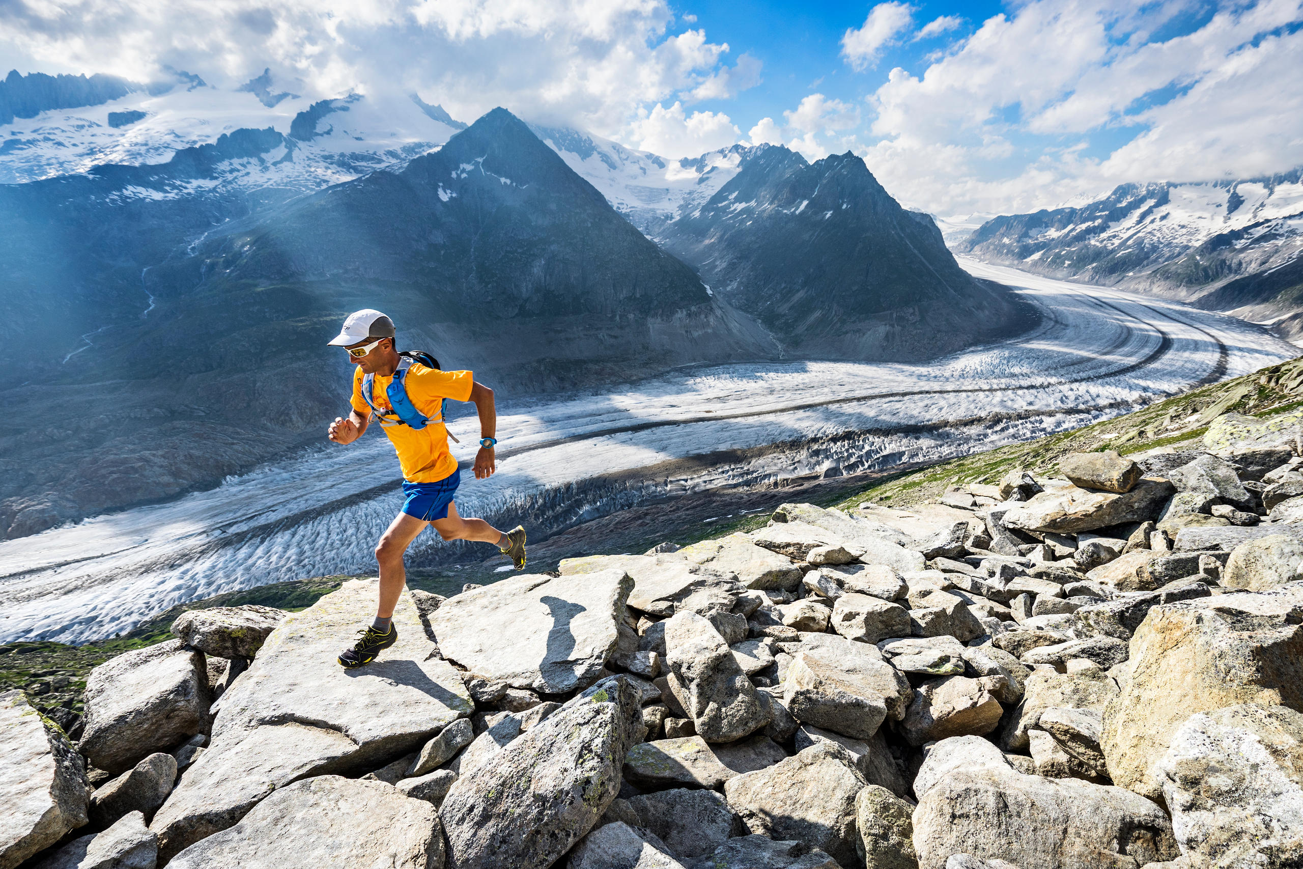 Un hombre practicando carrera de montaña con un glaciar como telón de fondo