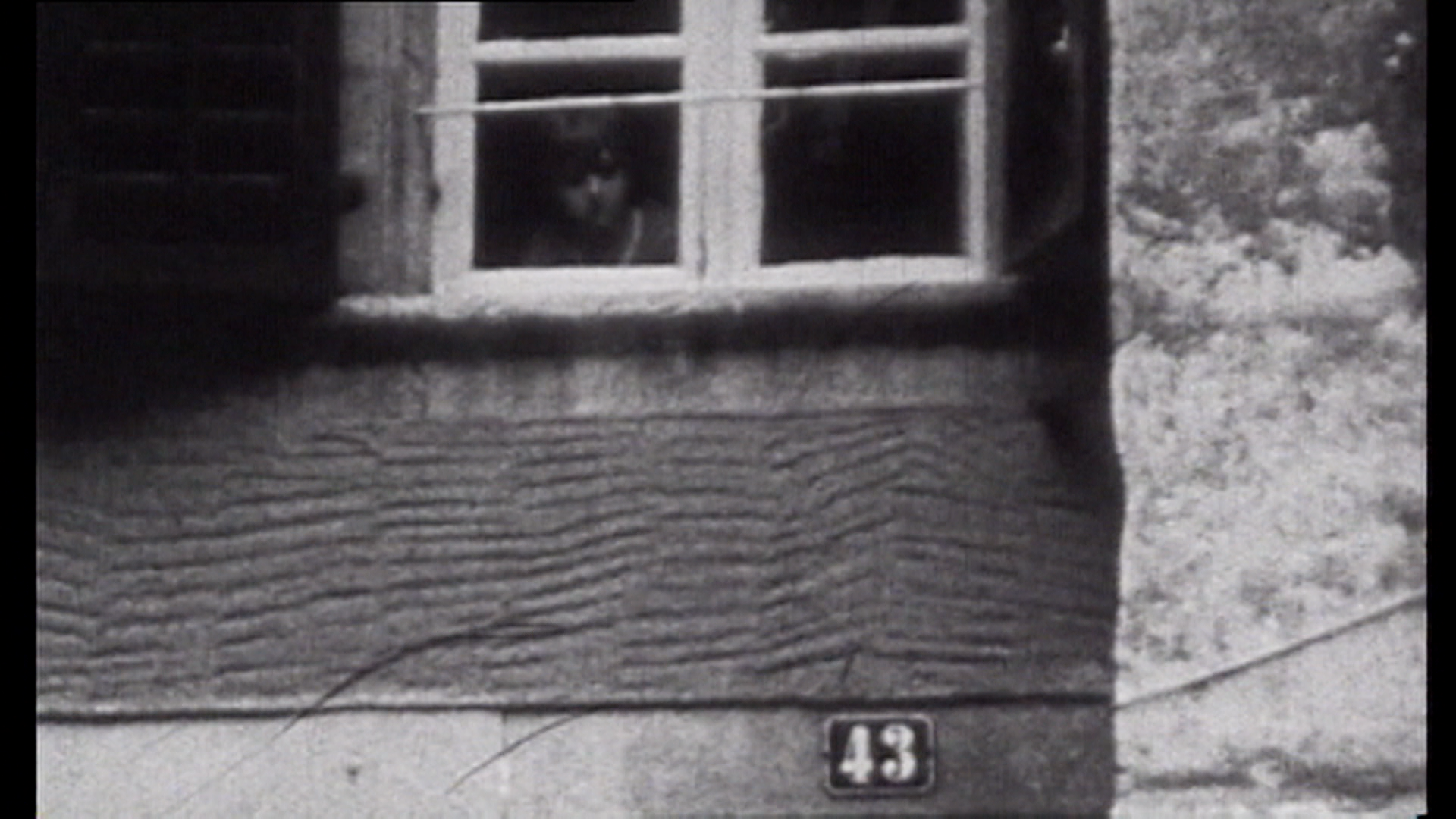 Bambino che osserva l esterno di casa sua dall angolo basso del vetro di una finestra