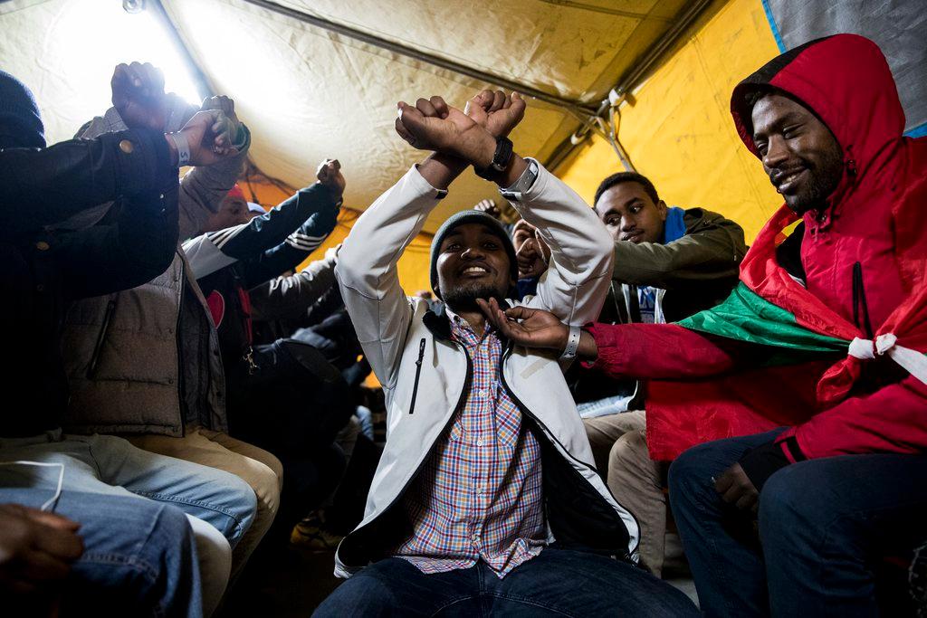 Ethiopian ethnic group Oromo migrants cheering after being evacuated from a makeshift camp in France.