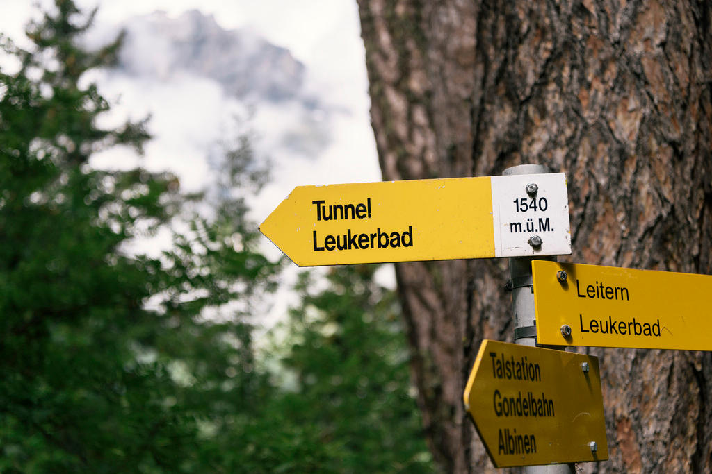 Signposts for hikers indicating the way to small Swiss municipaliteis.