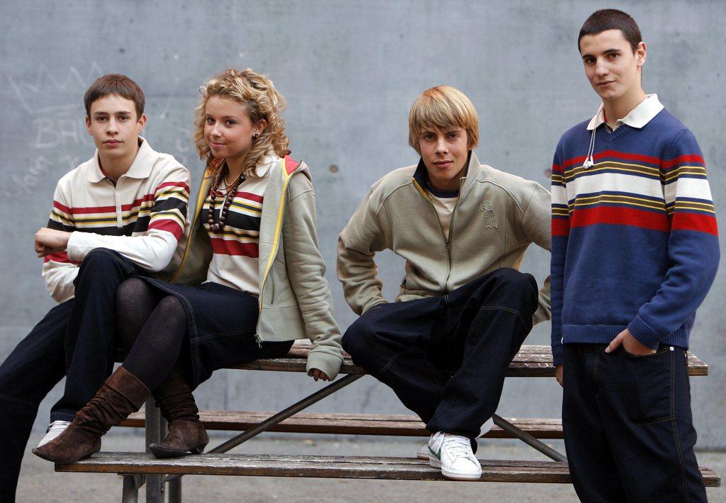 четверо подростков в свитерах и брюках