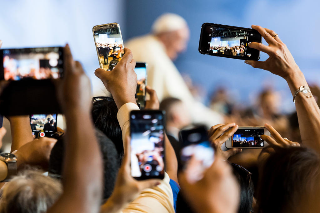 2018年6月21日星期四，信众在瑞士日内瓦的Palexpo会展中心大型弥撒中纷纷举起手机为教宗方济各拍摄照片。当天，教宗方济各飞赴日内瓦走访世界基督教联合会，以作为纪念世基联成立70周年的核心活动。