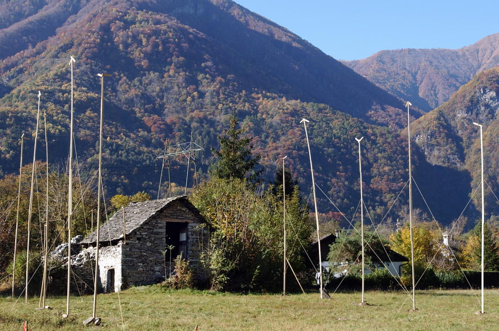 Traditional stone house in a Ticino mountain valley surrounded by construction profiles