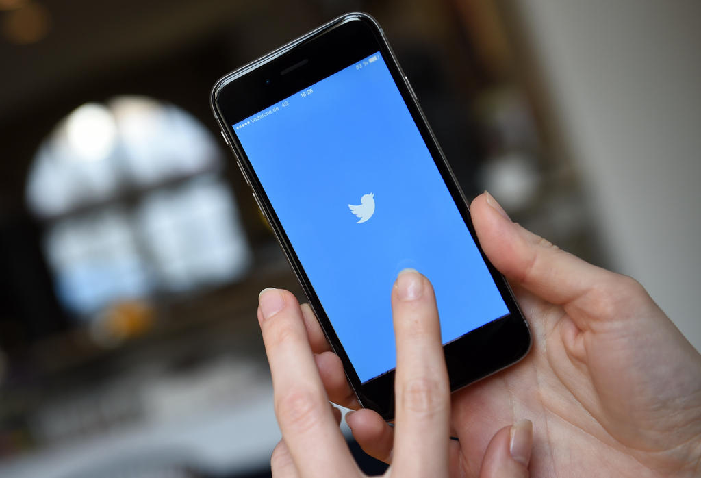 Hand holding phone with Twitter application open